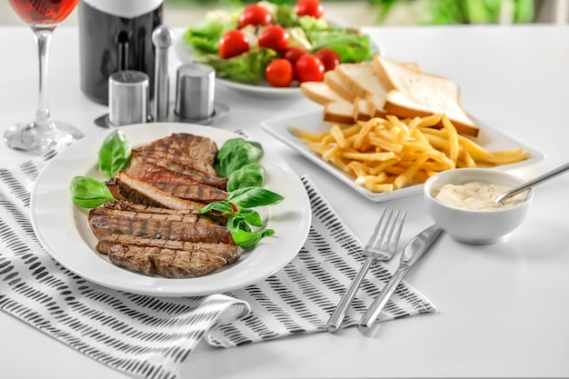 Plate with delicious grilled steak in restaurant