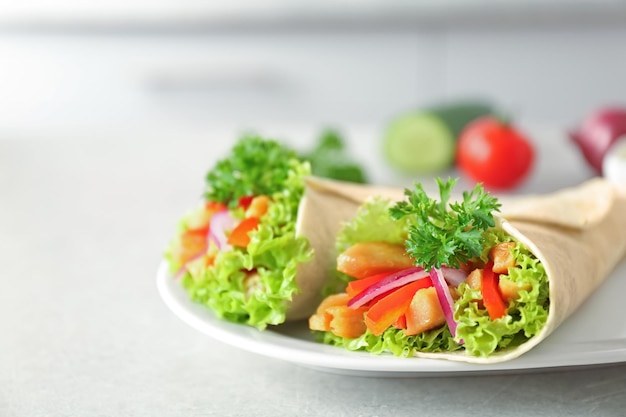 Plate with delicious kebab sandwiches on kitchen table