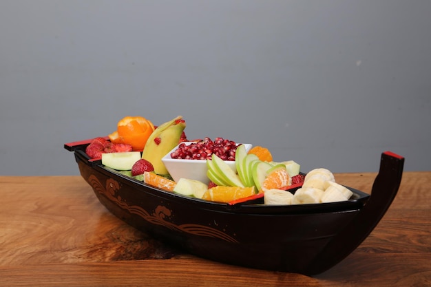 Plate with delicious mixed fruits and sliced fruits