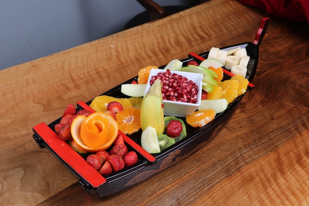 Plate with delicious mixed fruits and sliced fruits