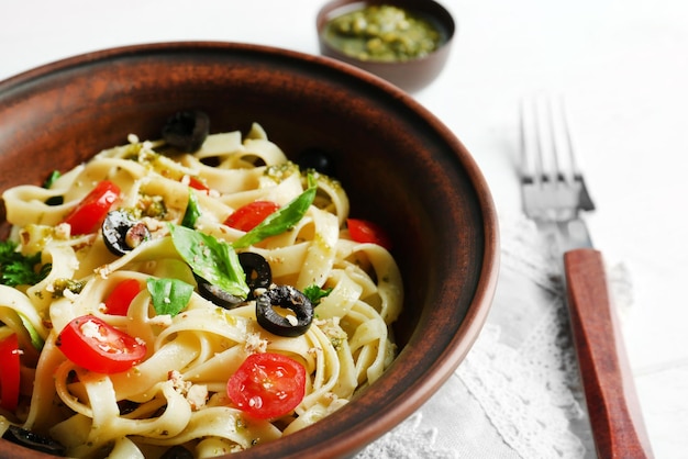 Plate with delicious pasta on wooden background