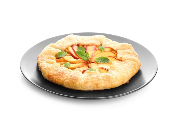 Plate with delicious peach galette on white