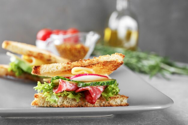 Plate with delicious sandwich on table closeup