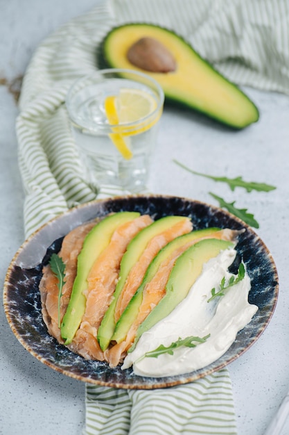 Plate with delicious slices of meat and avocado with sour cream sauce