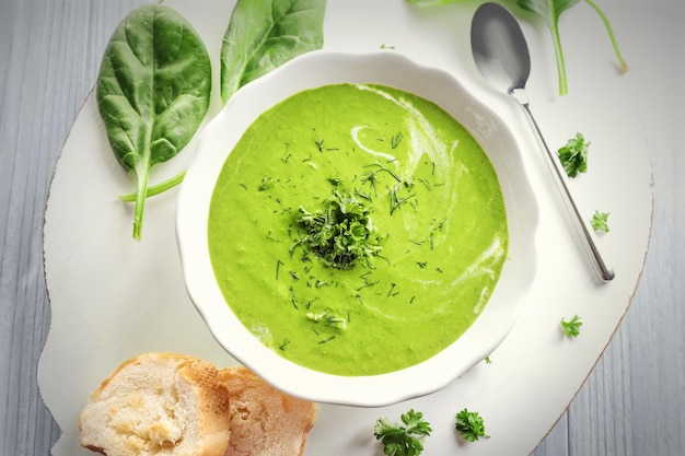 Plate with delicious spinach soup on table