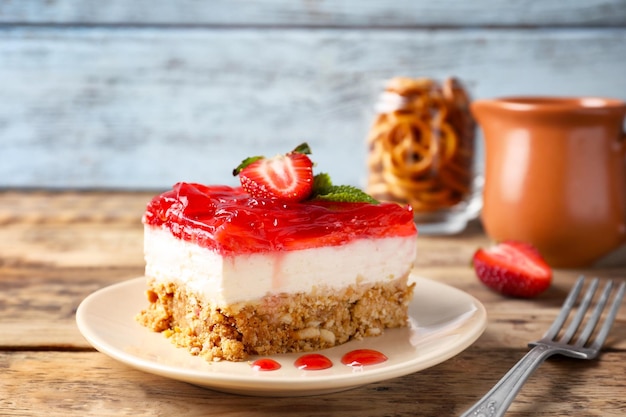 Plate with delicious strawberry pretzel salad on table