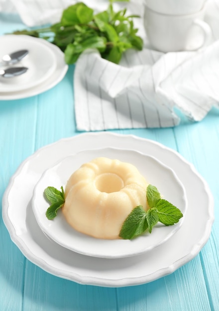 plate with delicious vanilla pudding on wooden table