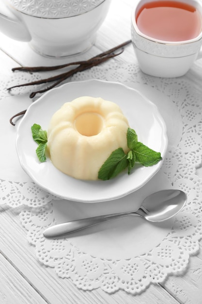 plate with delicious vanilla pudding on wooden table