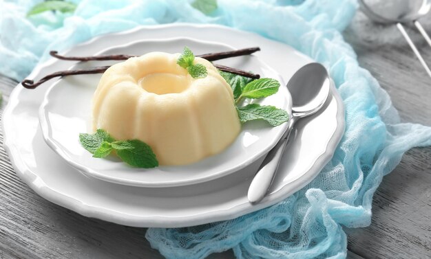 plate with delicious vanilla pudding on wooden table