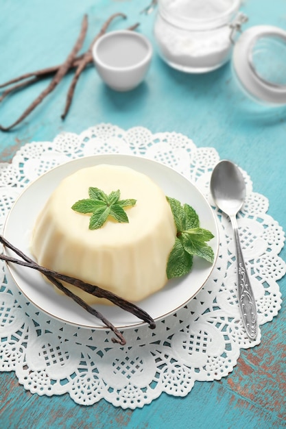 plate with delicious vanilla pudding on wooden table