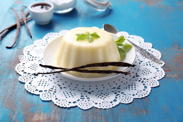 plate with delicious vanilla pudding on wooden table