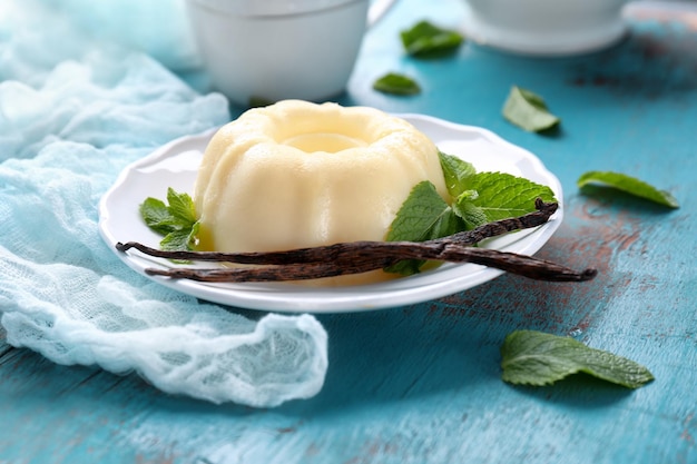 plate with delicious vanilla pudding on wooden table
