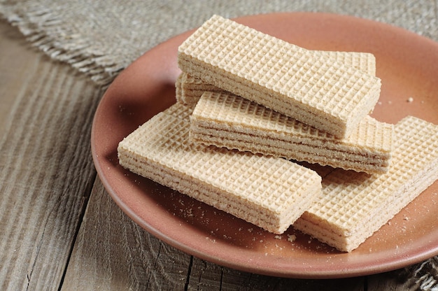 Plate with delicious wafers on a rustic wooden table