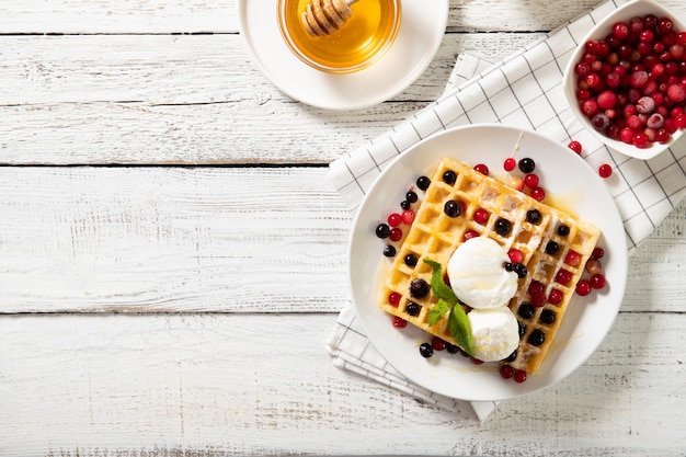 Foto piastra con deliziosi waffle con frutti di bosco e gelato. vista dall'alto, posto per il testo.