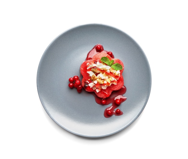 Plate with delicious watermelon salad on white surface