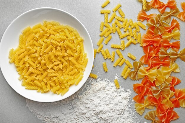 Plate with different kinds of pasta with cherry tomatoes on table