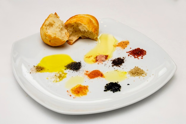 plate with different types of salt olive oil and bread on a plate white background food space