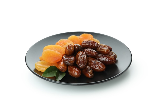 Plate with dried dates and apricots isolated on white