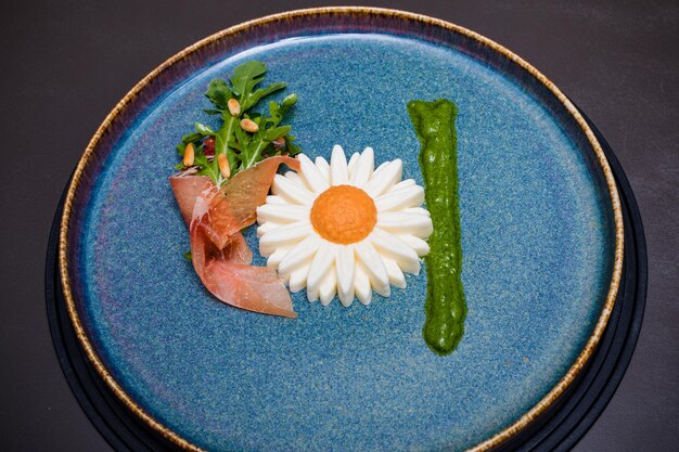 a plate with a flower and a piece of food on it