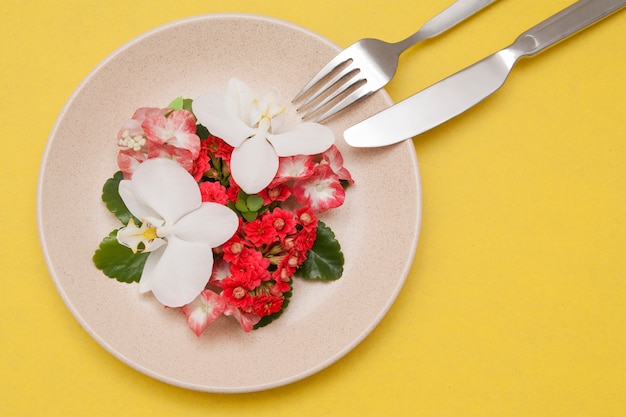 Plate with flowers on a yellow surface