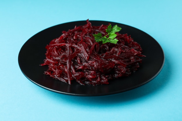 Photo plate with fresh beet salad on blue