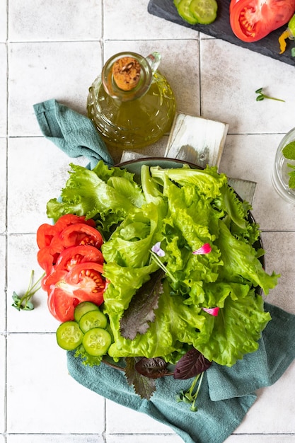 新鮮なグリーンサラダのプレートサラダの葉とキュウリのトマトとマイクログリーンのミックス上面図
