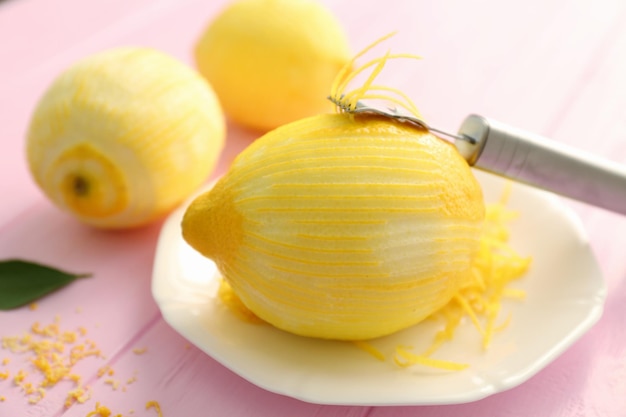 Plate with fresh peeled lemon and zest on table