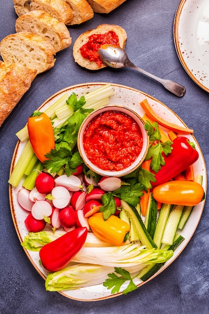 Plate with fresh raw vegetables and sauce