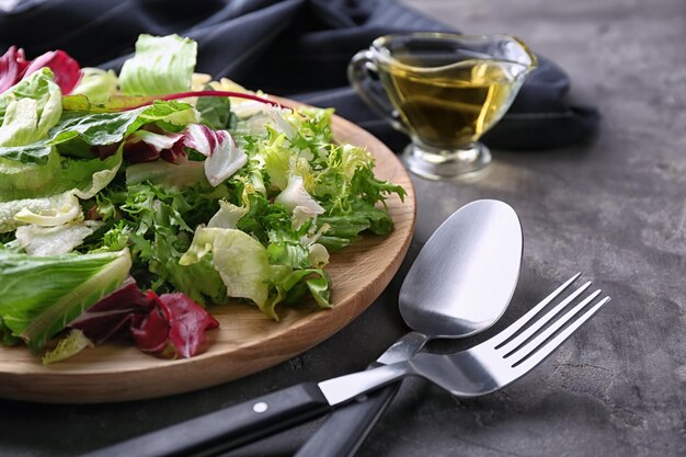 Plate with fresh salad on grey table closeup