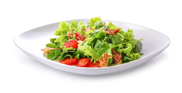 Plate with fresh tasty salad on white surface