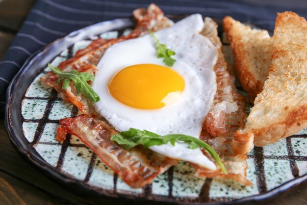 目玉焼きとベーコンのクローズ アップ プレート