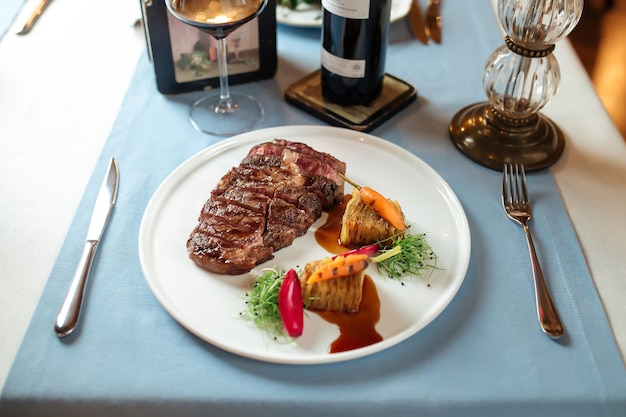 plate with grilled beef ribeye steak and potatoes