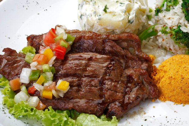 Plate with grilled steak rice potatoes salad Picanha