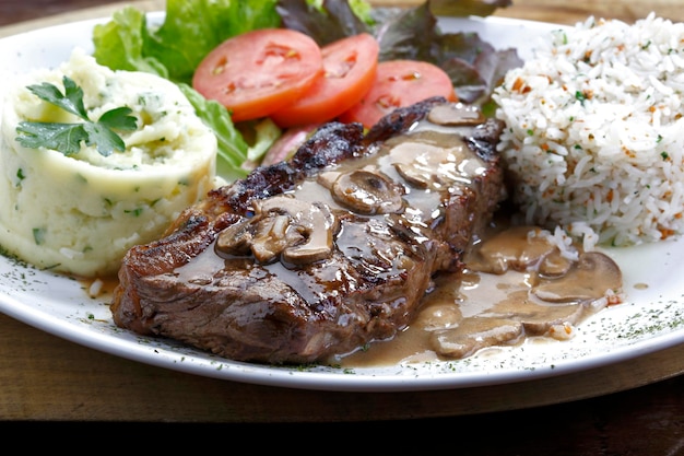 Plate with grilled steak rice potatoes salad Picanha