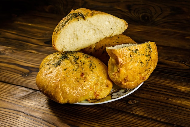 Plate with italian bun ciabatta on wooden table