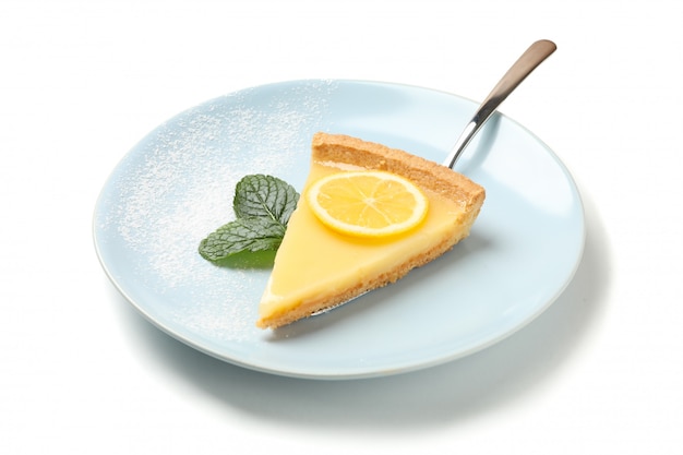 Plate with lemon tart slice and mint isolated on white