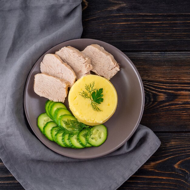 Plate with mashed potatoes, boiled meat and cucumber salad. Proper healthy diet