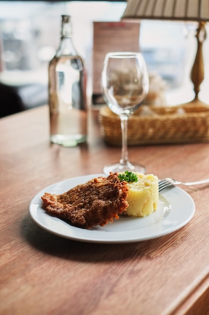 A plate with mashed potatoes and a toasted egg with tomatoes and a fork. 