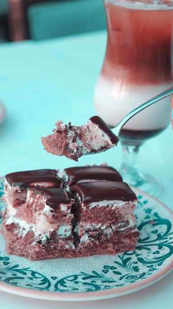 Foto un piatto con un pezzo di torta e una bottiglia di soda dietro