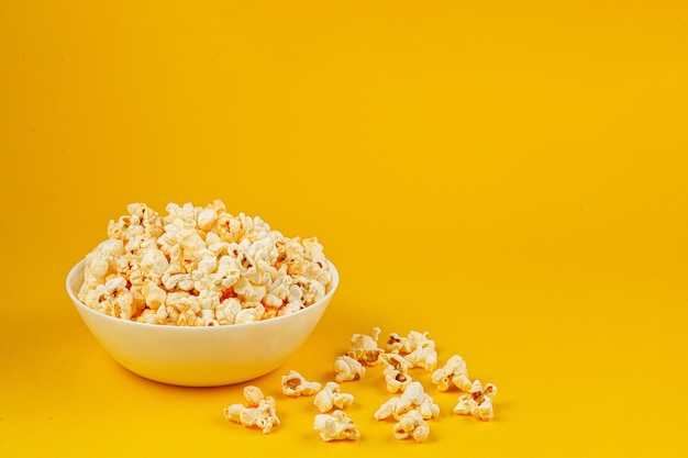 Plate with popcorn on a yellow background