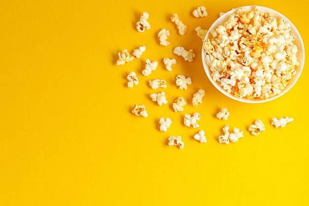 Plate with popcorn on a yellow background