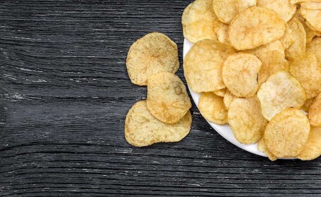 Plate with potato chips on the table Top view