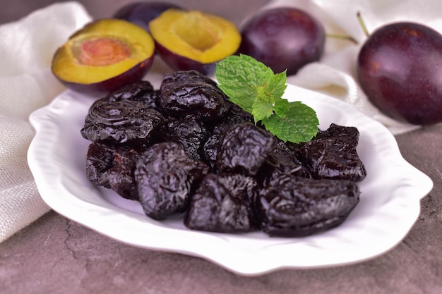 A plate with prunes. Close-up of dried plums.