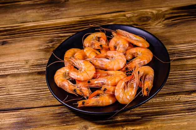 Plate with raw shrimps on a wooden table