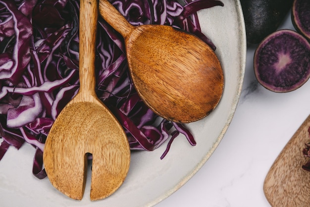 Plate with red cabbage cut with wooden spoons