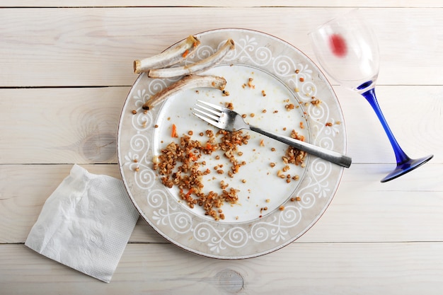 Foto piatto con i resti di cibo e il bicchiere con il resto del vino