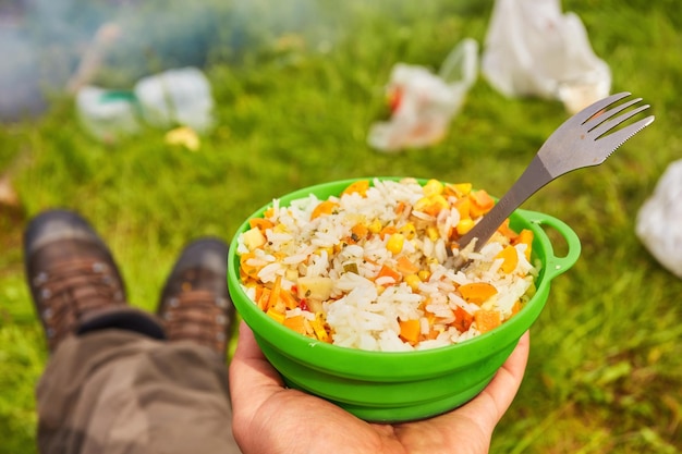 Plate with rice in the hands of a tourist