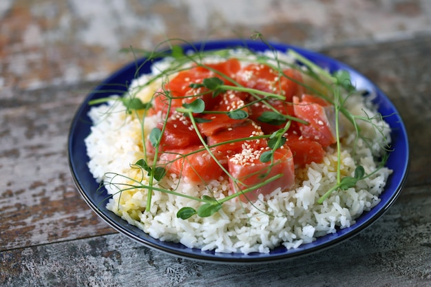 Plate with rice, salmon and micro greens.