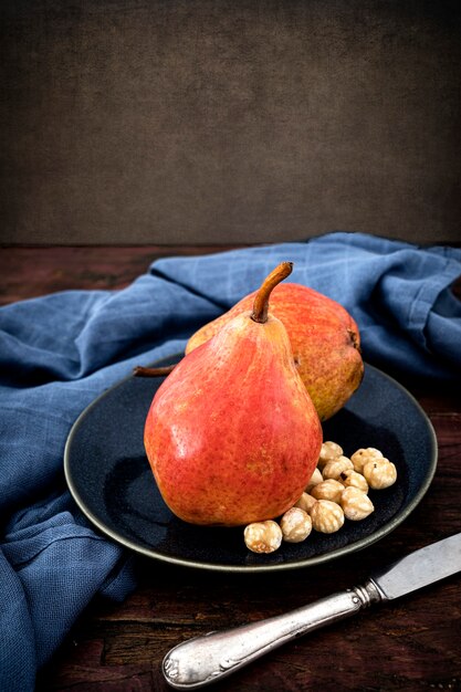 Plate with ripe pears and some hazelnuts