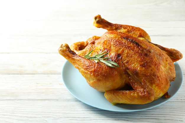 Plate with roast turkey on white wooden table